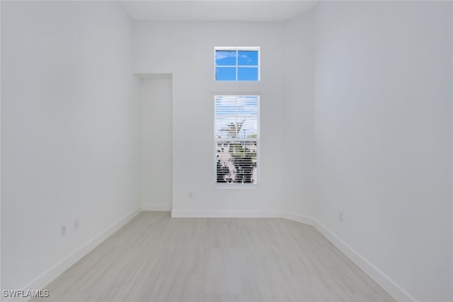 unfurnished room with light wood-style flooring and baseboards