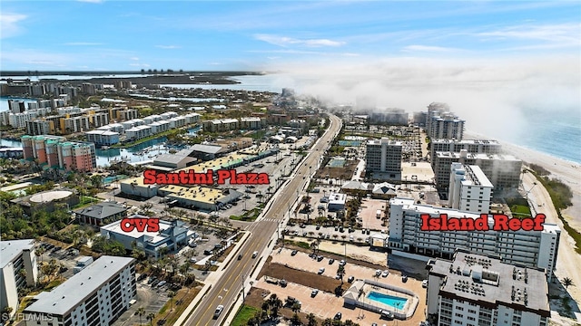 bird's eye view featuring a water view, a view of city, and a view of the beach