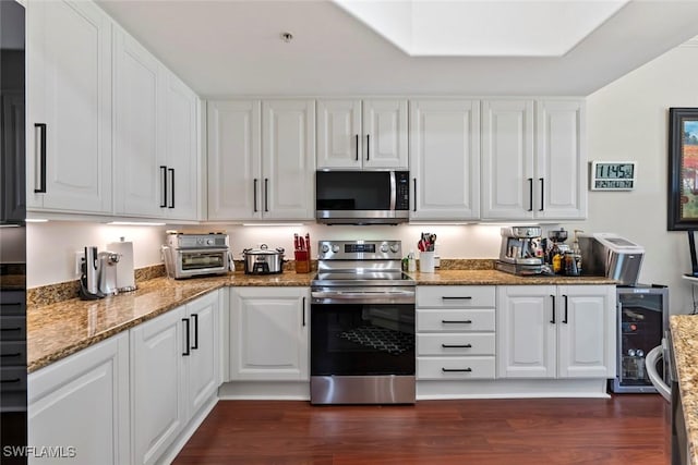 kitchen with dark wood-type flooring, wine cooler, stone countertops, white cabinetry, and stainless steel appliances