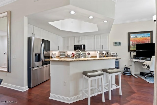 kitchen featuring white cabinets, dark hardwood / wood-style flooring, crown molding, and appliances with stainless steel finishes