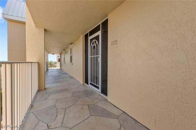 101 N Marion Ct Unit 122, Punta Gorda, FL 33950 - view of exterior entry featuring stucco siding, a balcony, a standing seam roof, and metal roof