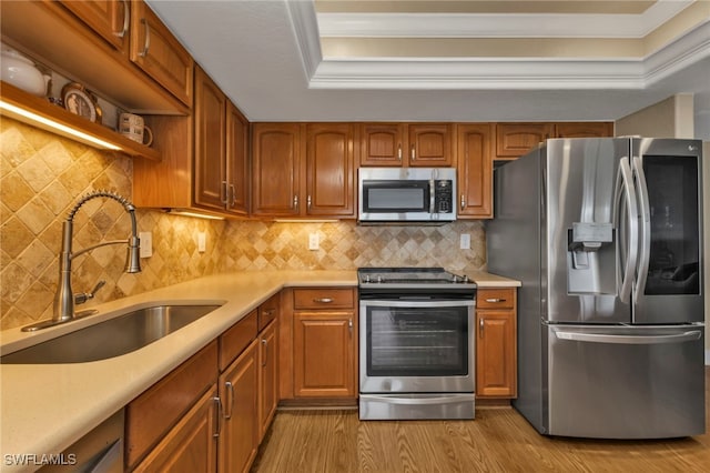 kitchen featuring stainless steel appliances, brown cabinetry, light countertops, and a sink