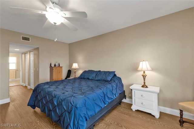 bedroom with baseboards, visible vents, ceiling fan, and wood finished floors