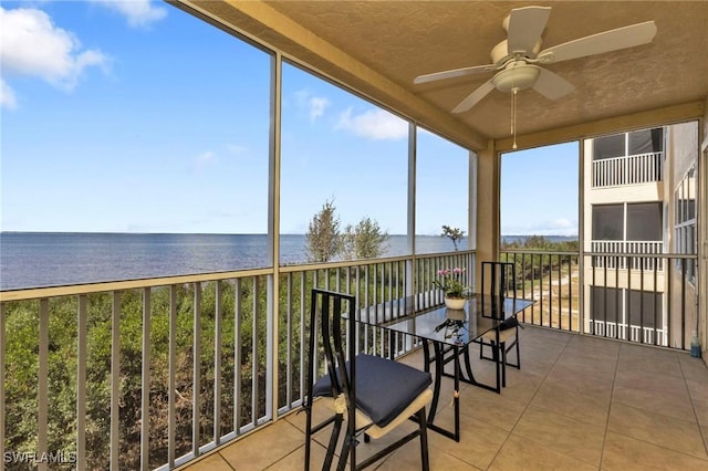 sunroom with a water view and a ceiling fan