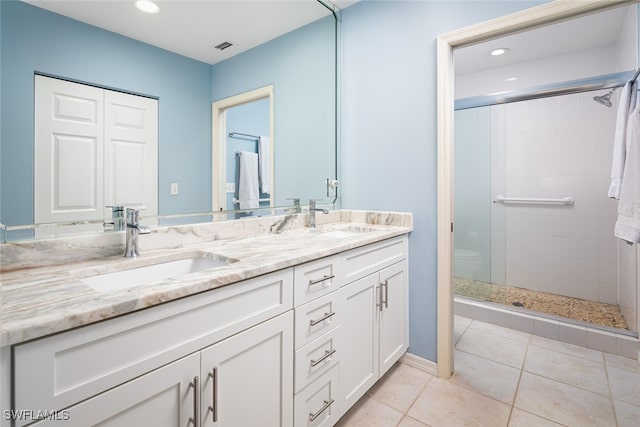 bathroom with tile patterned flooring, vanity, and a shower with shower door