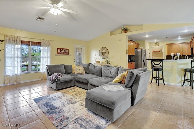 tiled living room featuring ceiling fan and vaulted ceiling