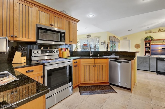 kitchen featuring lofted ceiling, sink, decorative backsplash, kitchen peninsula, and stainless steel appliances