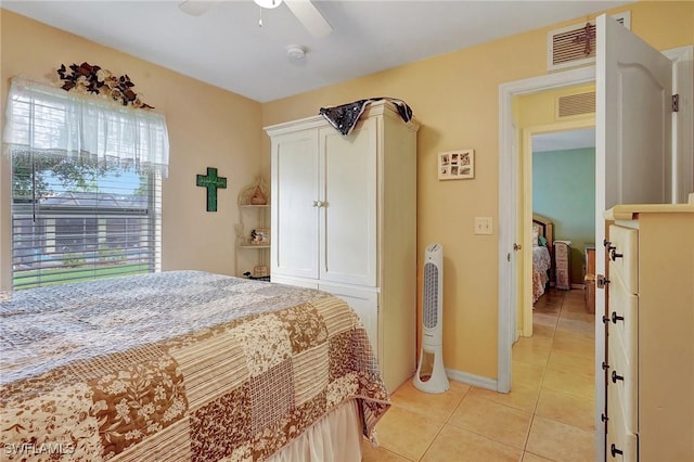 tiled bedroom with ceiling fan and multiple windows