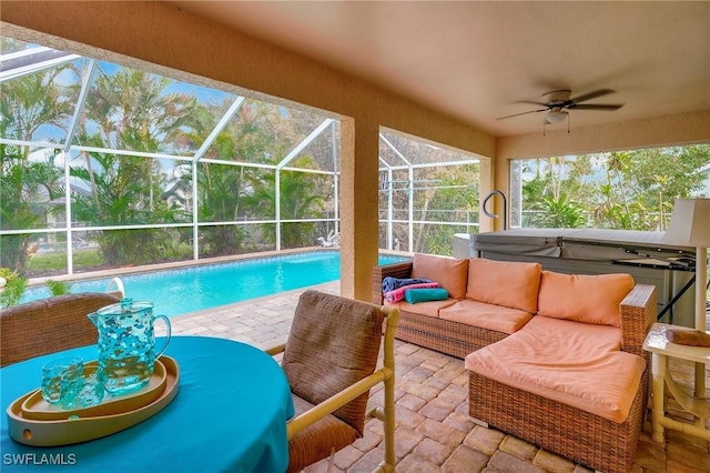 view of swimming pool with glass enclosure, ceiling fan, a jacuzzi, an outdoor hangout area, and a patio area