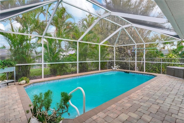 view of swimming pool featuring central air condition unit, glass enclosure, and a patio