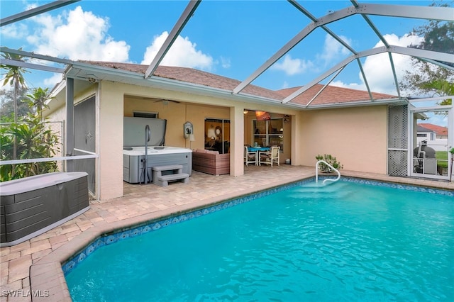 rear view of house featuring glass enclosure, ceiling fan, a patio, and a pool with hot tub