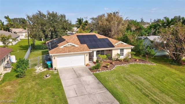 view of front of property featuring a front lawn, a garage, and solar panels