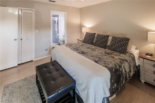 bedroom featuring ensuite bath, a closet, and wood-type flooring