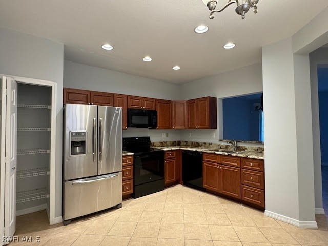 kitchen featuring light tile patterned floors, black appliances, sink, and light stone countertops