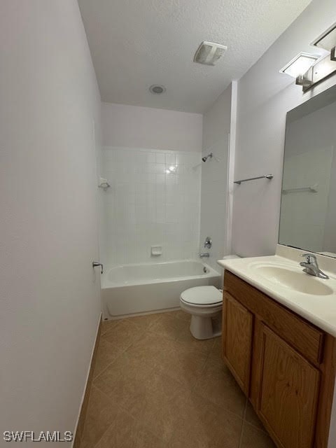 full bathroom with vanity, a textured ceiling, tile patterned flooring, toilet, and tiled shower / bath