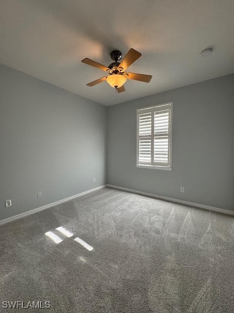 empty room featuring ceiling fan and carpet