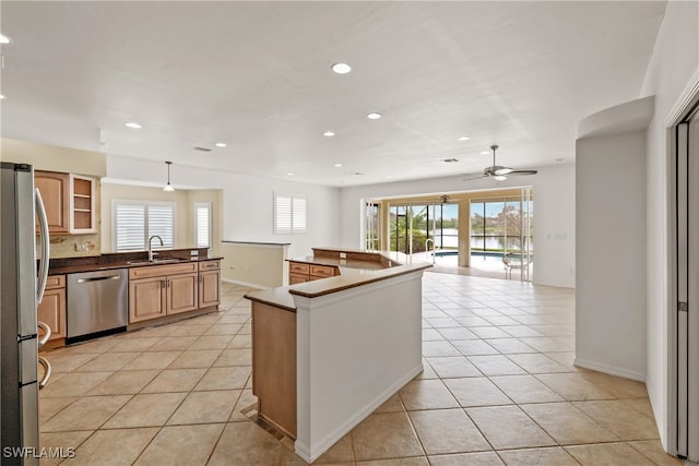 kitchen with ceiling fan, light tile patterned flooring, sink, and appliances with stainless steel finishes