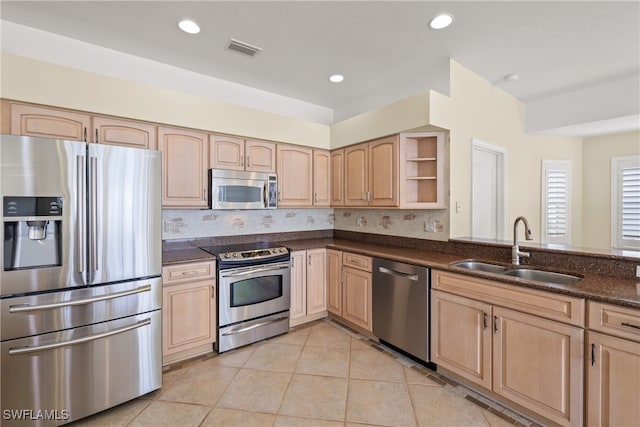 kitchen with light brown cabinets, sink, stainless steel appliances, and light tile patterned flooring