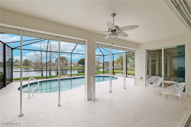 view of swimming pool featuring ceiling fan and a water view