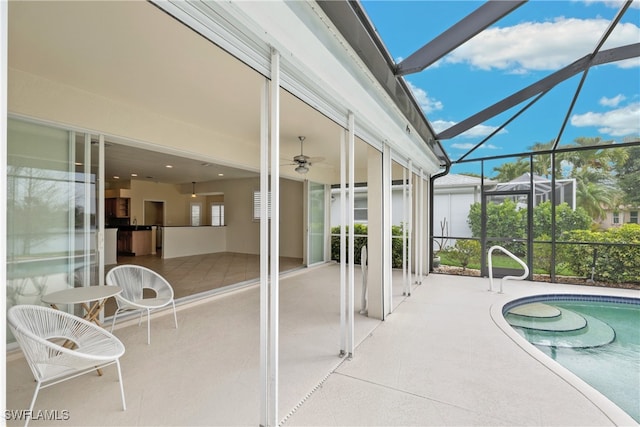 sunroom with ceiling fan and a swimming pool