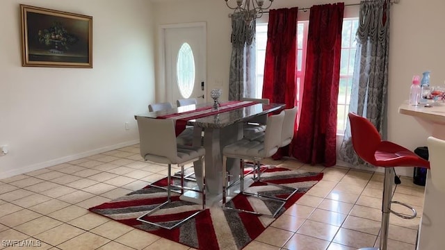 tiled dining space featuring an inviting chandelier