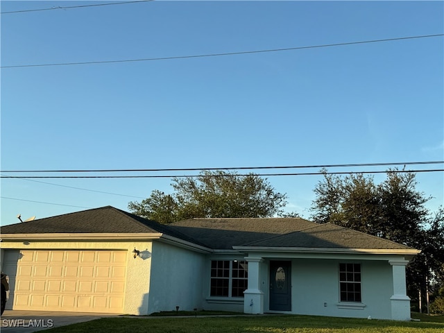 single story home featuring a front lawn and a garage