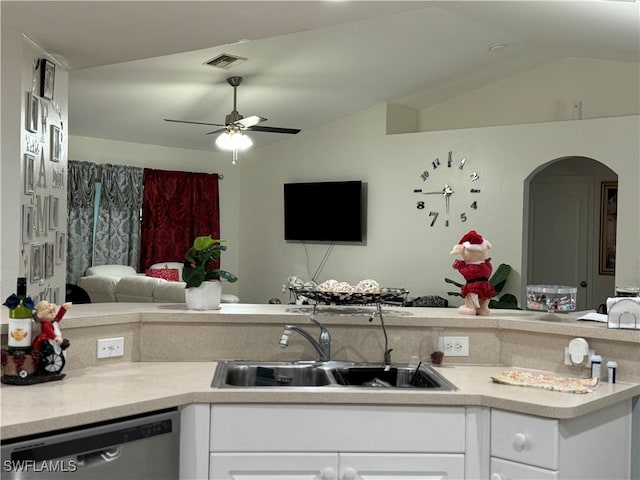 kitchen with lofted ceiling, white cabinets, sink, stainless steel dishwasher, and ceiling fan