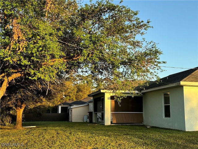 view of property exterior featuring a lawn and a sunroom