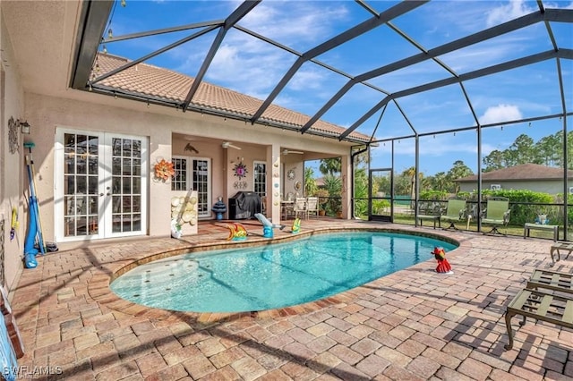 view of pool featuring french doors, ceiling fan, a lanai, and a patio area