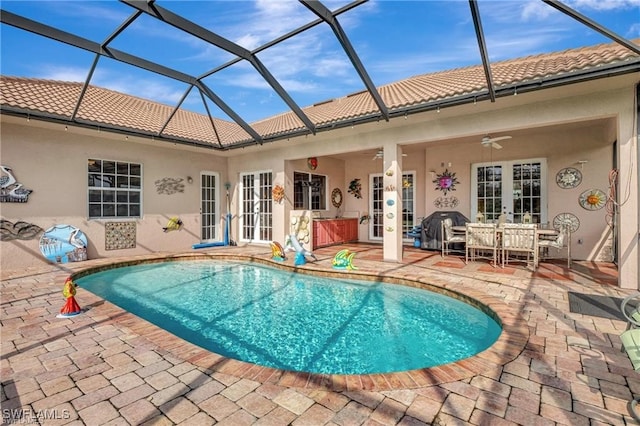 view of pool featuring a patio, french doors, ceiling fan, and glass enclosure