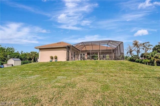 rear view of property with glass enclosure and a lawn