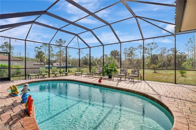 view of swimming pool featuring a lanai and a patio area