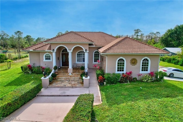 mediterranean / spanish home featuring a front yard