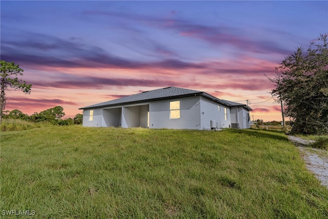 property exterior at dusk with a lawn