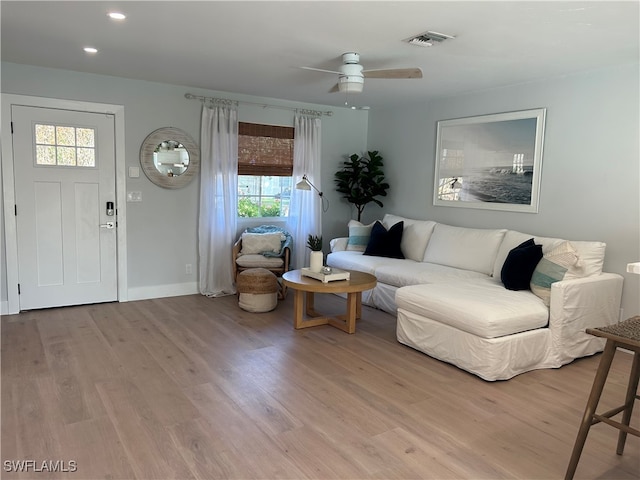 living room featuring ceiling fan, plenty of natural light, and light wood-type flooring