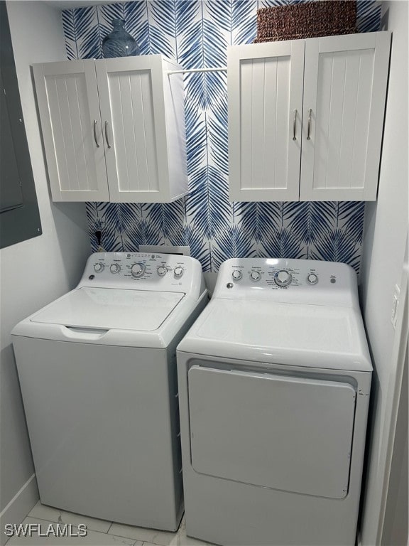 clothes washing area with electric panel, cabinets, and washing machine and clothes dryer