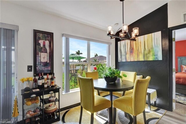 dining space featuring a chandelier and light hardwood / wood-style floors