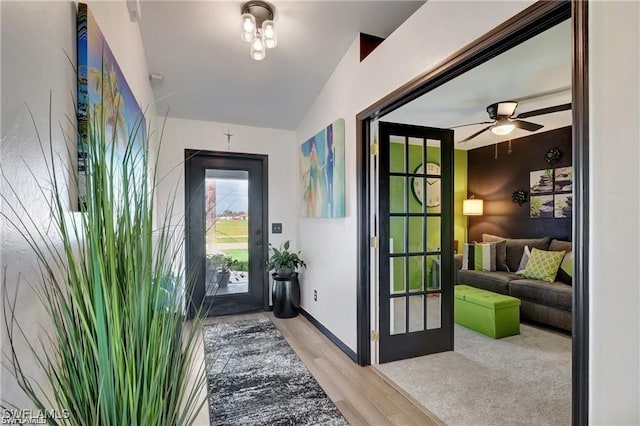 doorway to outside with ceiling fan, lofted ceiling, and light hardwood / wood-style flooring