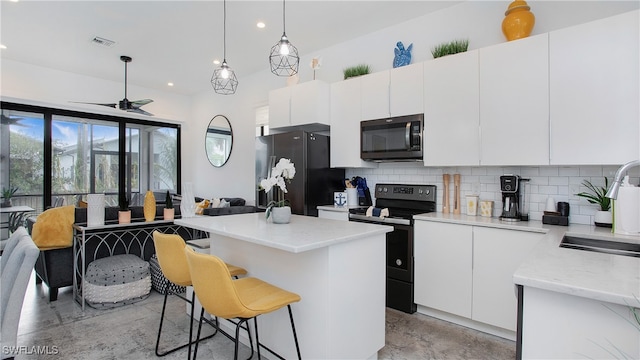 kitchen featuring black appliances, white cabinetry, pendant lighting, and tasteful backsplash