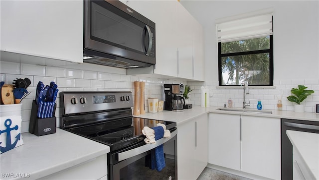 kitchen with sink, black appliances, and white cabinetry