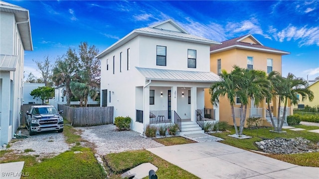 3016 Van Buren Ave, Naples, FL 34112 - view of front of home featuring stucco siding, a standing seam roof, a porch, metal roof, and fence