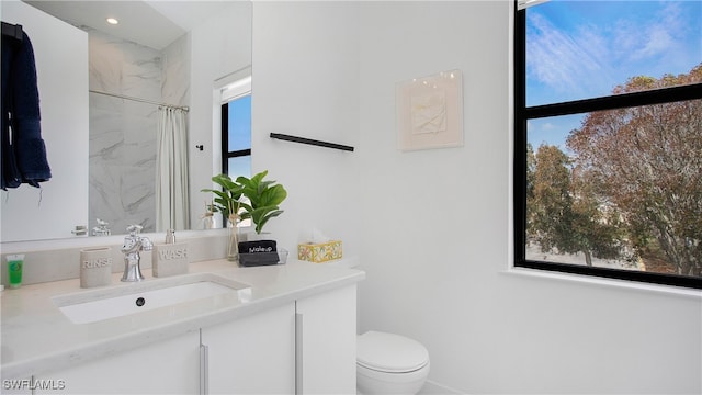 bathroom with vanity, toilet, walk in shower, and plenty of natural light