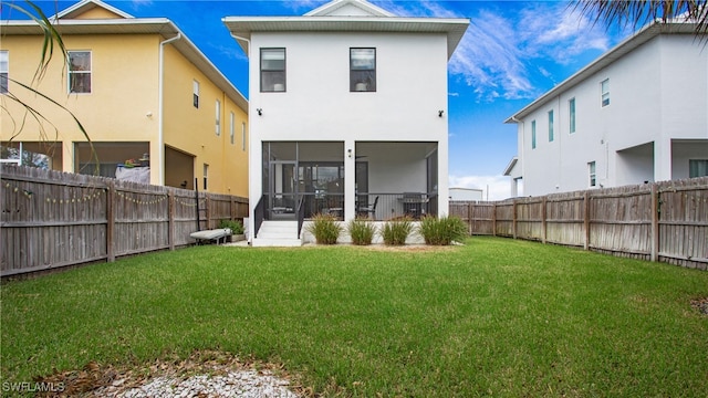 back of house featuring a sunroom and a lawn