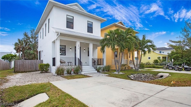 3016 Van Buren Ave, Naples, FL 34112 - view of front of home with stucco siding, covered porch, a standing seam roof, and fence