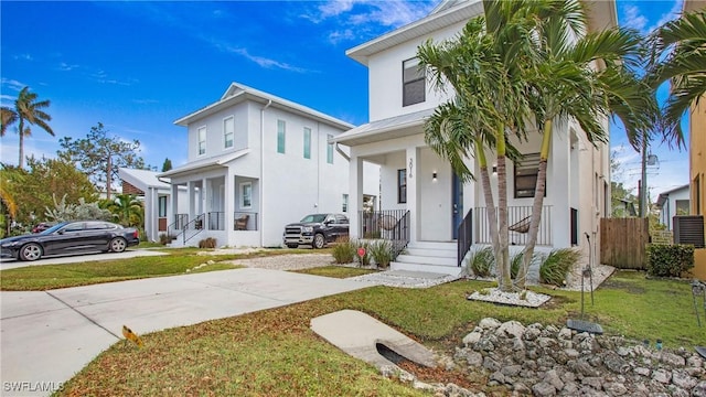 3016 Van Buren Ave, Naples, FL 34112 - view of front of home with stucco siding, covered porch, a front yard, and a standing seam roof