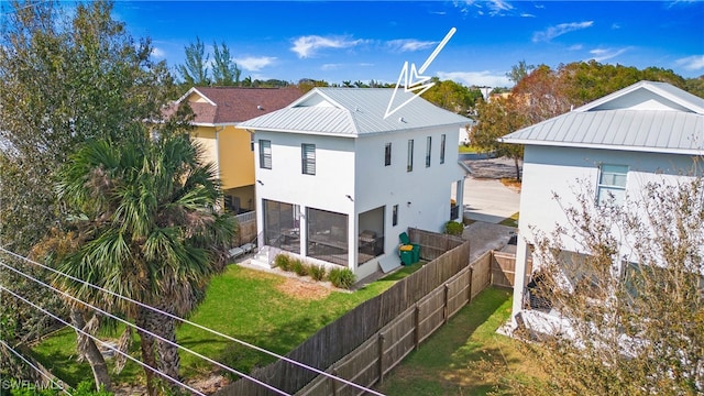 rear view of property with a lawn and a sunroom