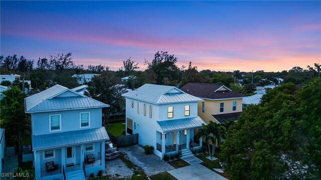 3016 Van Buren Ave, Naples, FL 34112 - view of front of home featuring covered porch, metal roof, stucco siding, a standing seam roof, and fence