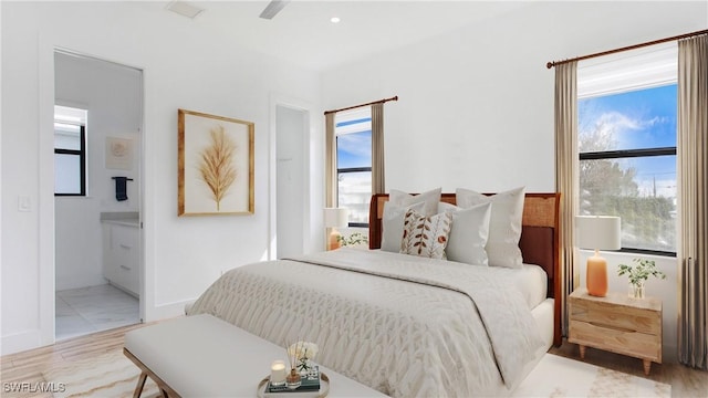 3016 Van Buren Ave, Naples, FL 34112 - bedroom with multiple windows, ensuite bath, and baseboards