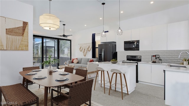 kitchen with stainless steel appliances, backsplash, sink, pendant lighting, and white cabinets