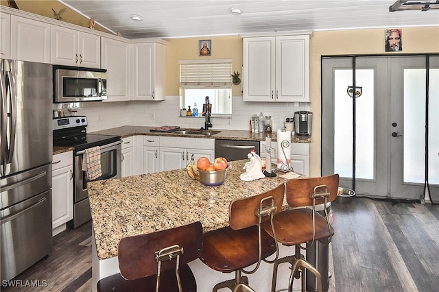 kitchen featuring white cabinetry, a wealth of natural light, sink, and appliances with stainless steel finishes